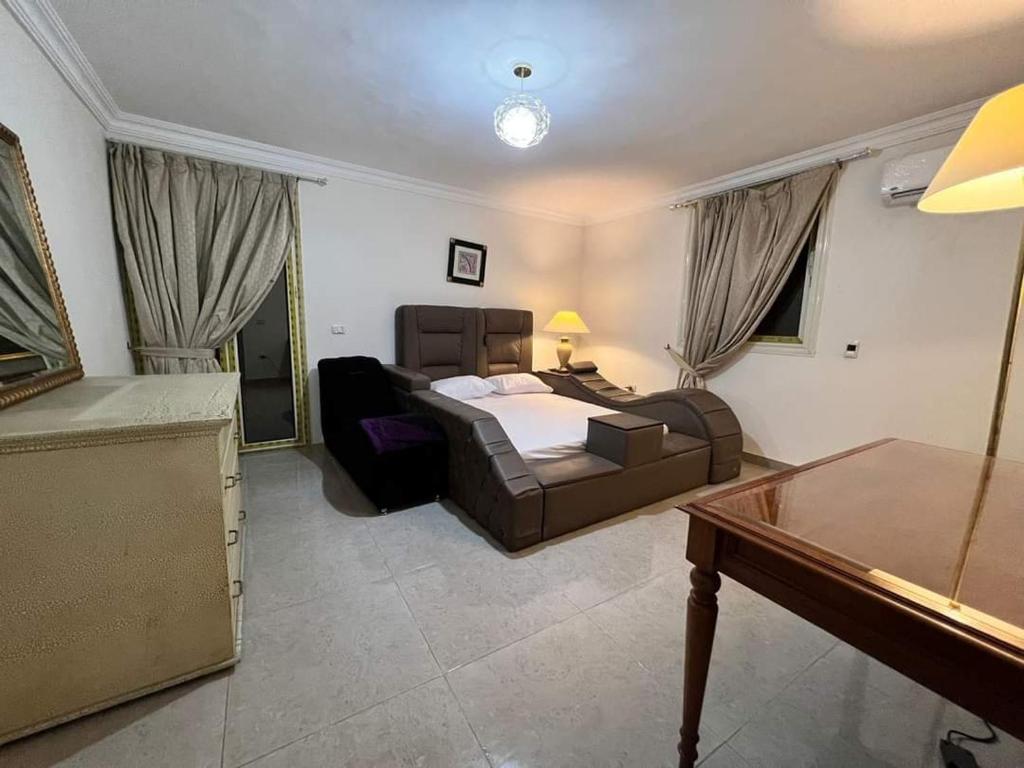 a bedroom with a bed and a couch and a table at شقه مفروشه فندقيه الترا مودرن فيو رائع لاصحاب الرقي والتمييز in Cairo