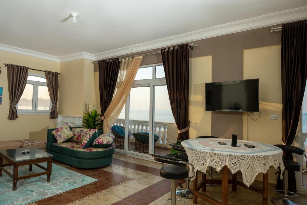 sunshine villa في سفاجا: غرفة معيشة مع تلفزيون وأريكة وطاولة
