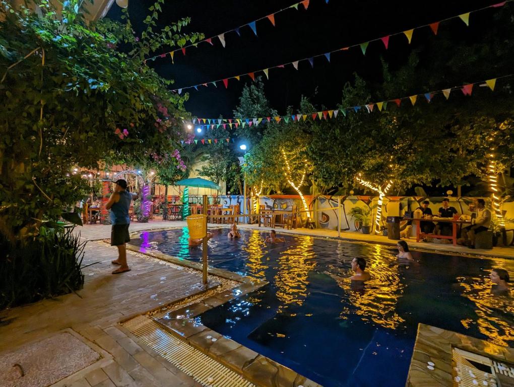 un groupe de personnes dans une piscine la nuit dans l'établissement Blue Diamond Hostel, à Battambang