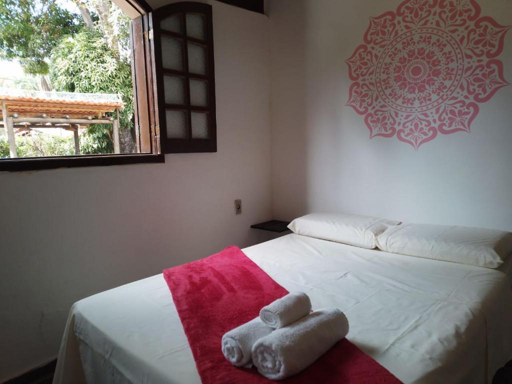 Un dormitorio con una cama blanca con toallas. en Pousada Quintão en Santana do Riacho