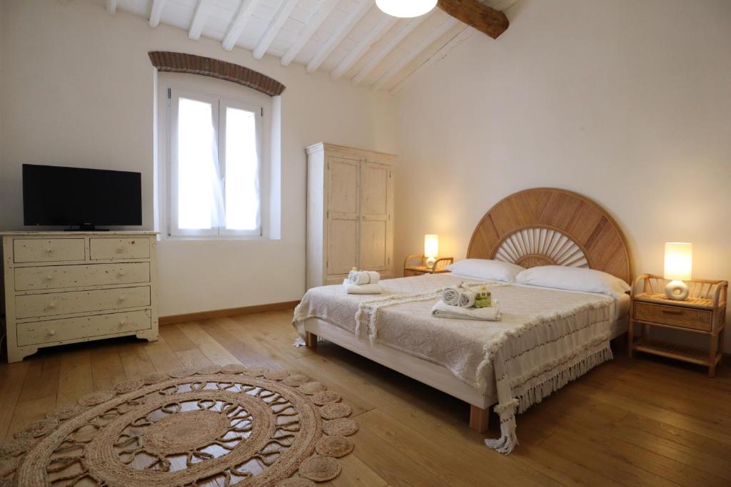 ein Schlafzimmer mit einem großen Bett und einem TV in der Unterkunft Wishlist - Casa Vacanze in Campiglia Marittima