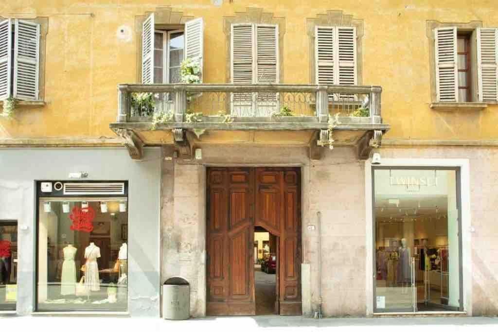 a building with a wooden door and a balcony at Palazzo del Giglio in Reggio Emilia