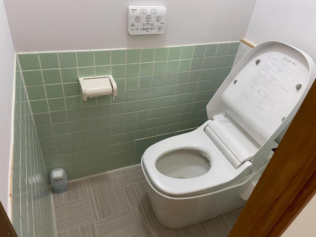 een badkamer met een toilet en een groene tegelwand bij Watatsumi no Yado 1981 - Vacation STAY 55945v in Iki