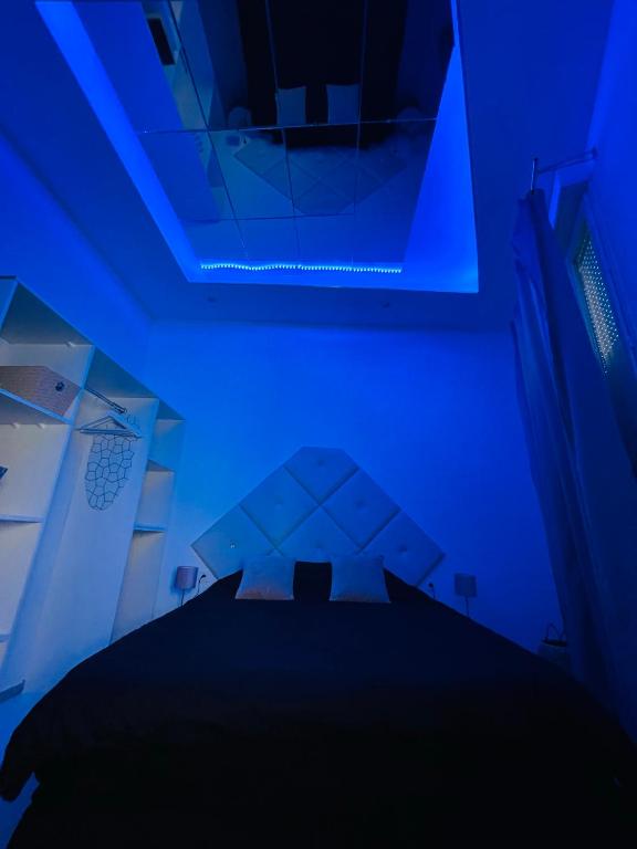 a blue room with a bed and a blue light at jolie maison individuelle 50 m2 ,design et climatisée, tout confort, wifi, terasse privée , 5 min plage et autoroute, stationnement gratuit in Marseille