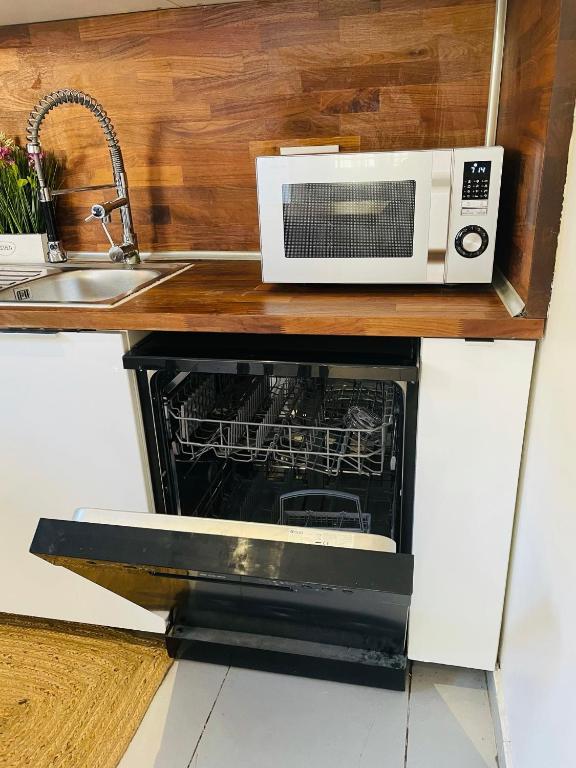 a microwave oven sitting on top of a kitchen counter at jolie maison individuelle 50 m2 ,design et climatisée, tout confort, wifi, terasse privée , 5 min plage et autoroute, stationnement gratuit in Marseille