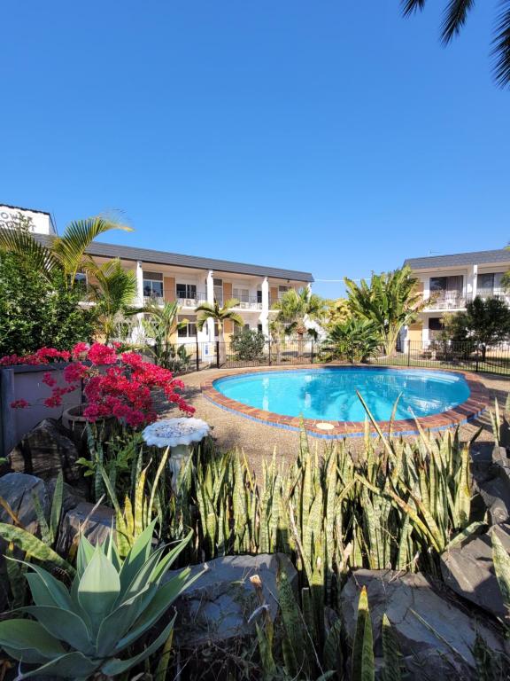 a swimming pool in front of a building at Tower Court Motel in Hervey Bay