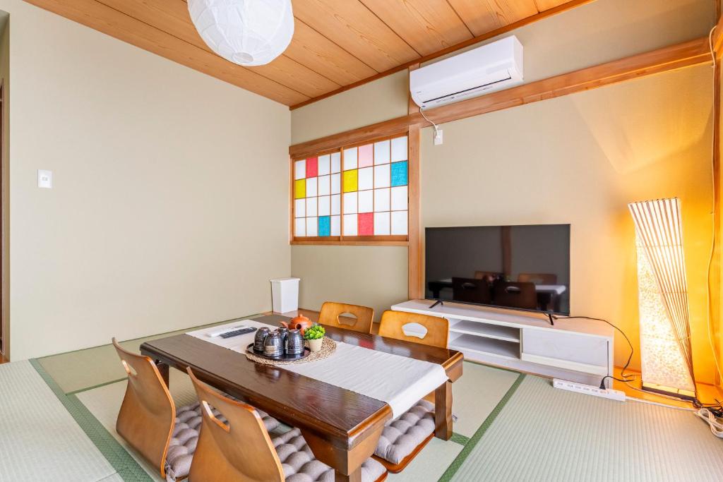 uma sala de jantar com uma mesa e cadeiras e uma cama em BISK PARK TOKYO - 4LDK Spacious House - Easy Access to Asakusa, Skytree area & Airport em Tóquio