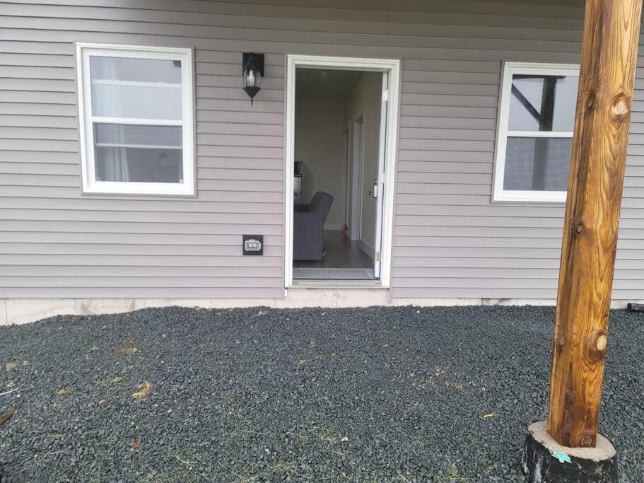 a white house with a door and a chair in it at Docker in Timberlea