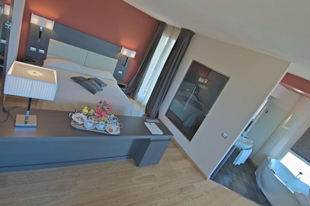 a bedroom with a bed and a table with a lamp at Zen Hotel Versilia in Marina di Pietrasanta