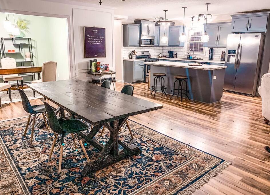 uma grande cozinha com uma mesa de madeira e cadeiras em Beautiful 3-bedroom home next to Ft Bragg em Fayetteville