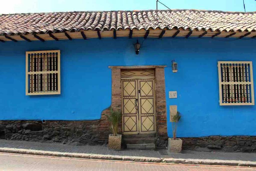 una casa azul con puerta y ventanas en La Casa Azul del Ventorrillo: Hospedaje Historico en Bogotá