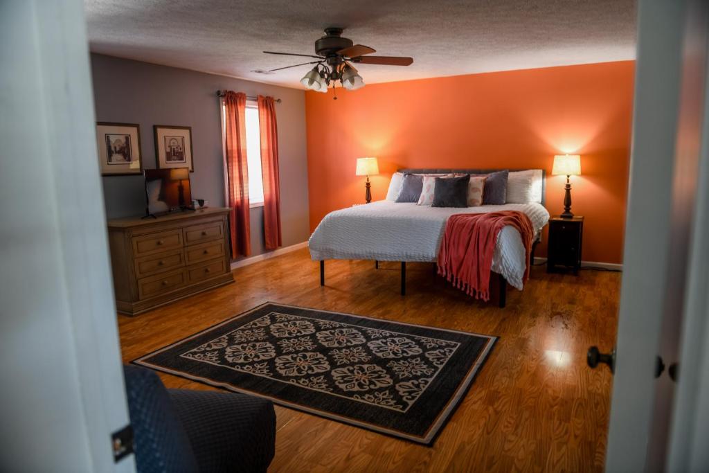 a bedroom with an orange wall with a bed and a rug at 5 Star with Direct Access to Brimstone Recreation Game Room Comfortable Up to 4 Bedrooms Stylish in Huntsville