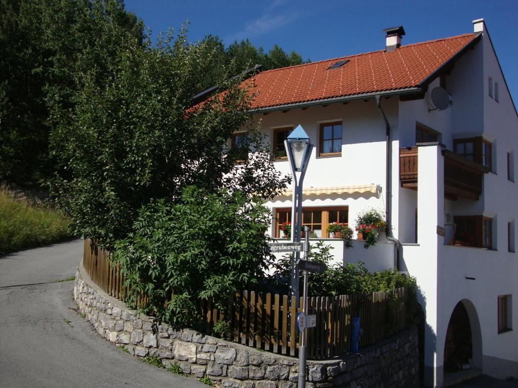 ein weißes Haus mit einem Zaun und einem Straßenlicht in der Unterkunft Haus Müller in Fiss
