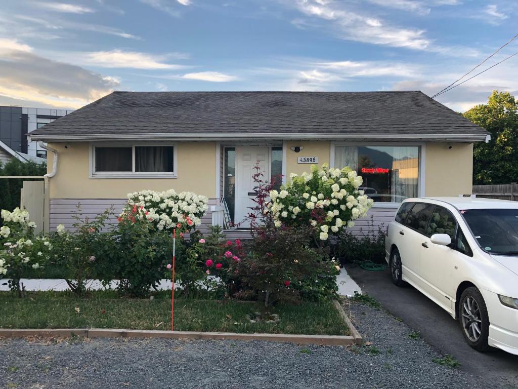 une voiture blanche garée devant une maison dans l'établissement Shady Willow Guest House -Coach house & Privet Small Compact Rooms with separate entrance, à Chilliwack