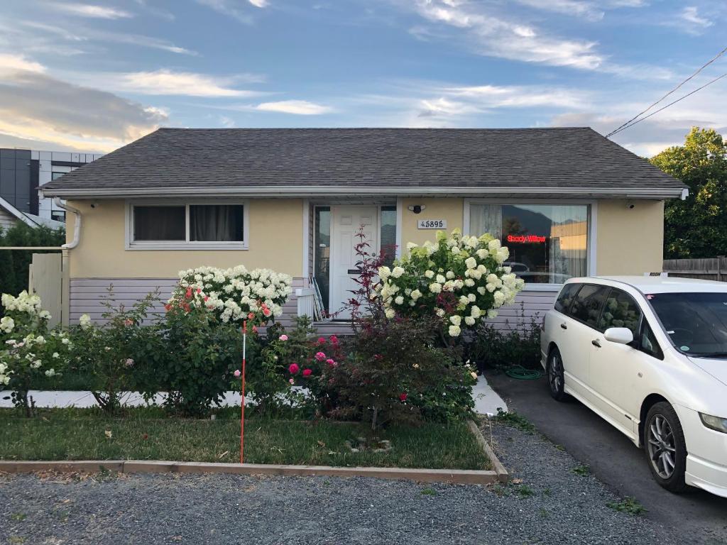 a white car parked in front of a house at Shady Willow Guest House -Coach house & Privet Small Compact Rooms with separate entrance in Chilliwack