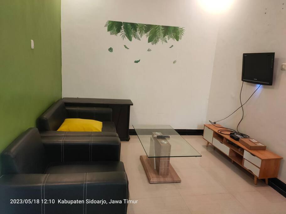 sala de estar con sofá y mesa en Homestay Sidoarjo - Comfort en Gedangan