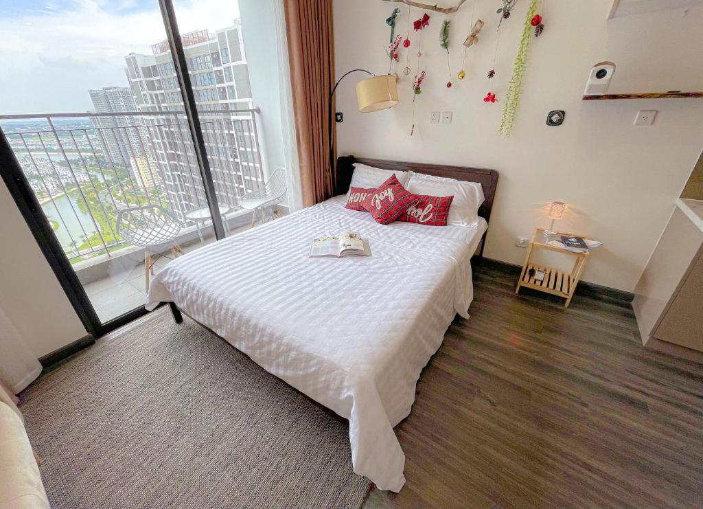 een slaapkamer met een bed met rode kussens en een raam bij Monday Homestay -R103 Vinhomes Ocean Park-Gia Lam-Ha Noi in Gia Lâm Pho