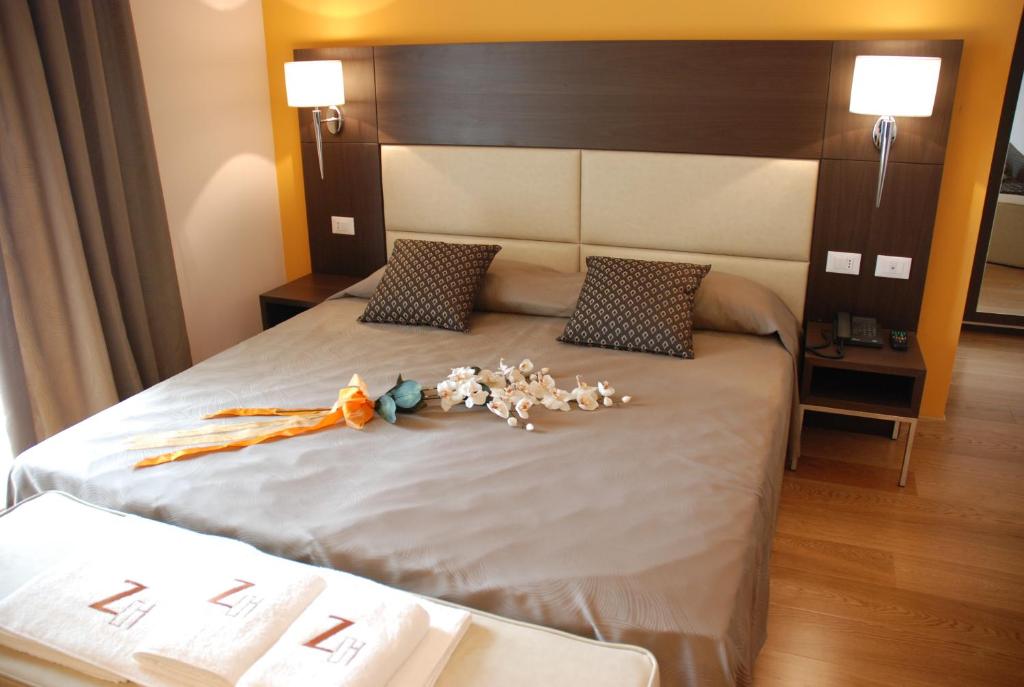 a bedroom with a bed with flowers on it at Zen Hotel Versilia in Marina di Pietrasanta