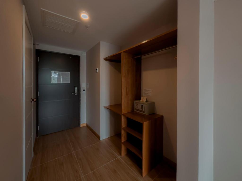 a hallway with a closet with a door and a microwave at MIRAFLORES CITY HOTEL in Lima