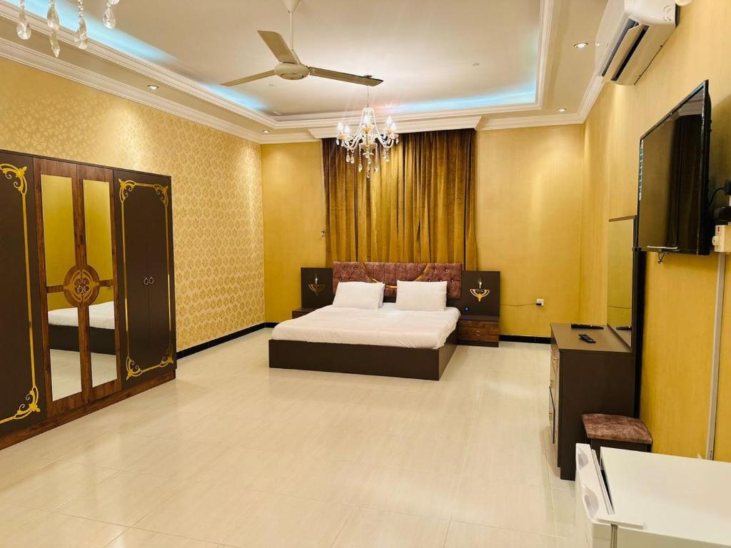 1 dormitorio con 1 cama y TV en البيت الأبيض للشقق المفروشة White House, en Salalah