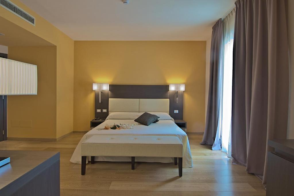a bedroom with a bed and a large window at Zen Hotel Versilia in Marina di Pietrasanta