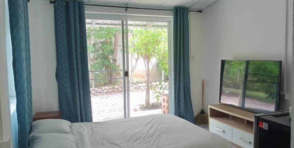 a bedroom with a bed and a tv and a window at Mem Homestay 