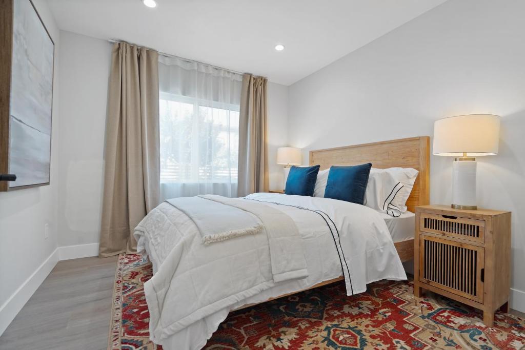 um quarto com uma cama com almofadas azuis e uma janela em Premier 1BR w/Bath in the Center of Culver City em Los Angeles