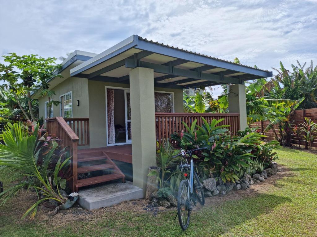 a house with a bike parked in front of it at Dominic's Beach Bungalow in Muri