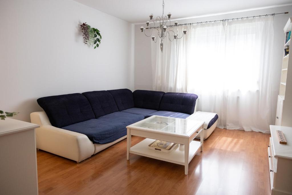 a living room with a blue couch and a table at Sarah´s apartment Bratislava in Bratislava