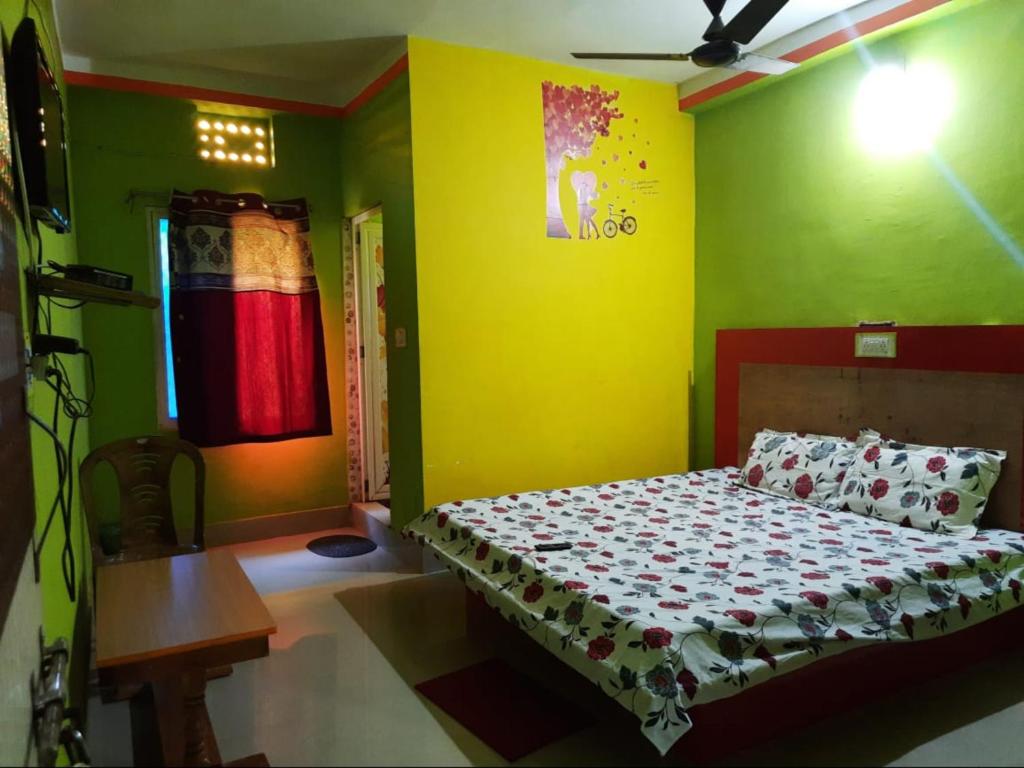 ein Schlafzimmer mit einem Bett und einer gelben Wand in der Unterkunft Goroomgo Sun Plaza Lodge konark in Konark
