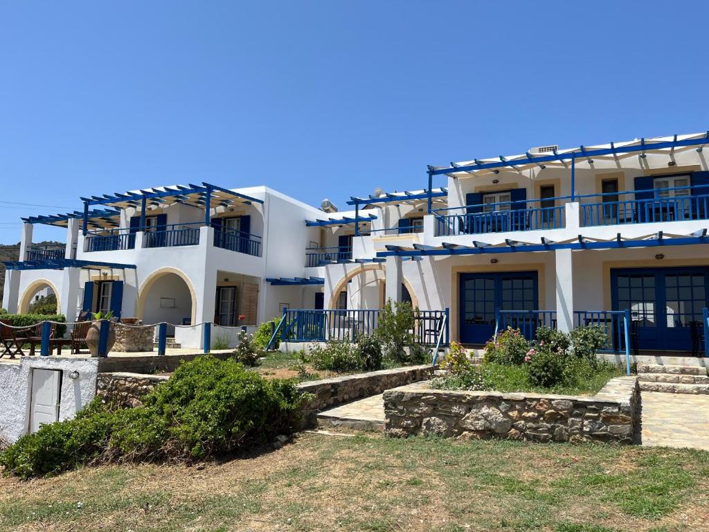 um grande edifício branco com varandas azuis e escadas em ΞΕΝΟΔΟΧΕΙΟ ΑΚΡΩΤΗΡΙ em Platia Ammos