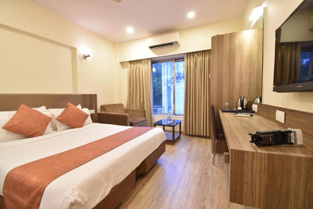 Cette chambre comprend un lit et un bureau. dans l'établissement Hotel Atlantic, à Mumbai