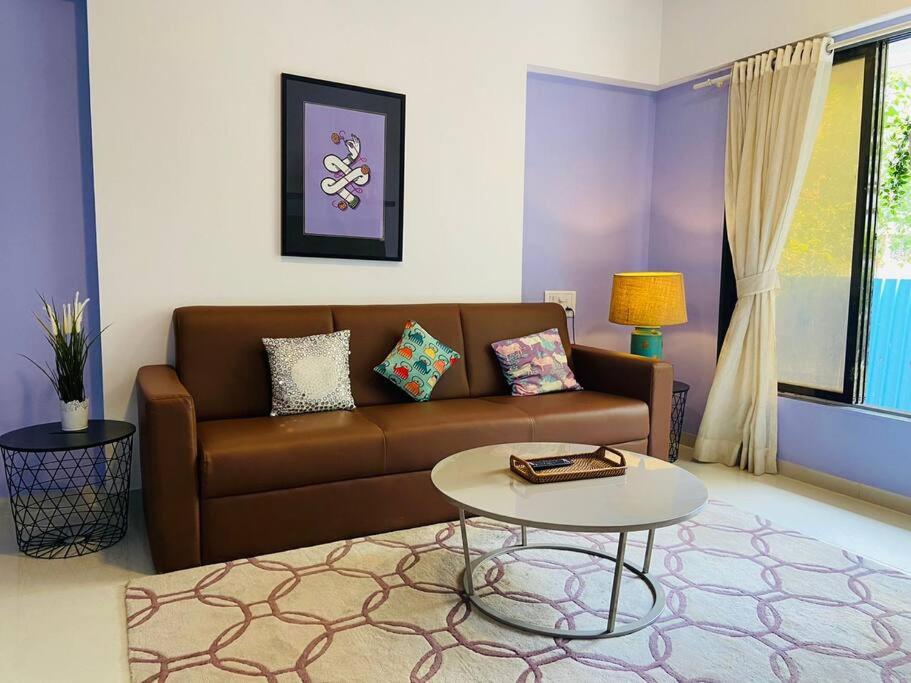 a living room with a couch and a table at Pali Carters Building 101, 20th Road, Khar West by Connekt Homes in Mumbai