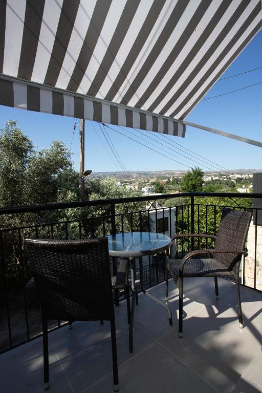 a table and chairs on a balcony with a view at Costas Apartments in Polis Chrysochous