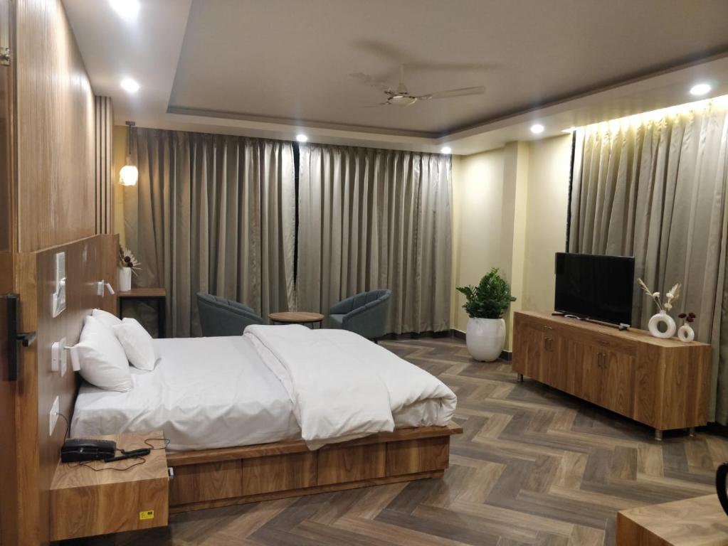 a hotel room with a bed and a television at Green Icon Hotels & Resorts in Kandogal
