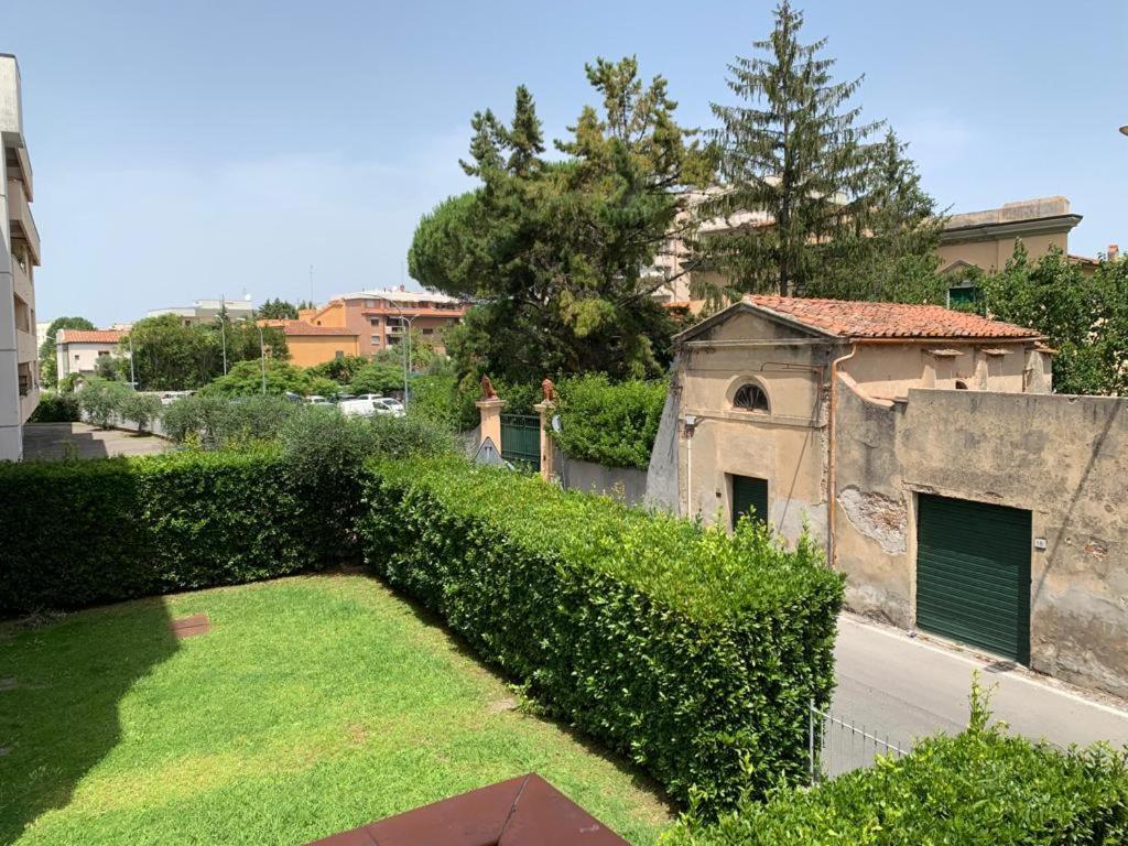 een met klimop overdekt gebouw met een tuin met een groene heg bij Sosta Paradisa in Pisa