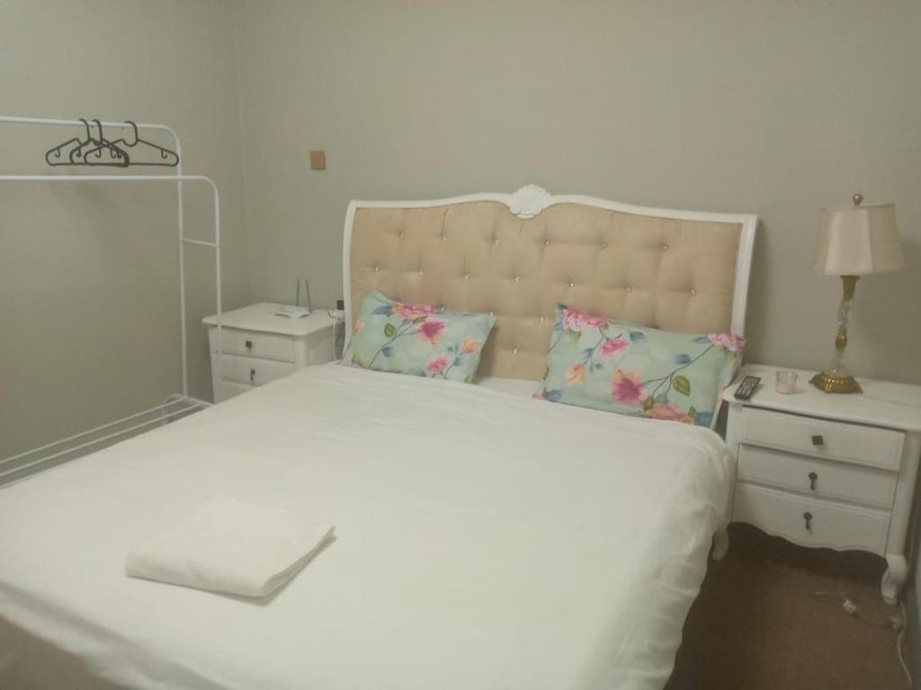 um quarto com uma grande cama branca e uma mesa de cabeceira em Private Room in shared Apartment em Abu Dhabi