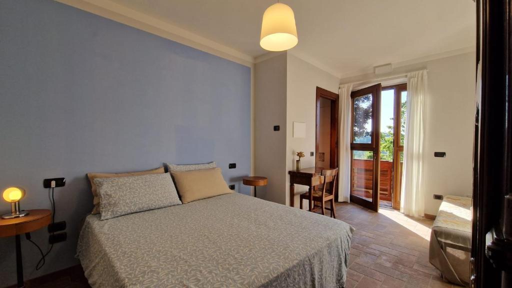 a bedroom with a bed and a desk and a window at BnB Bagno di Bosco in Gubbio