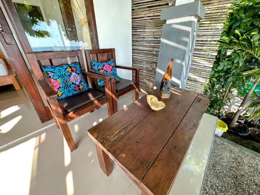 einen Holztisch und zwei Stühle auf einer Veranda in der Unterkunft Kumpul Beach in Amed