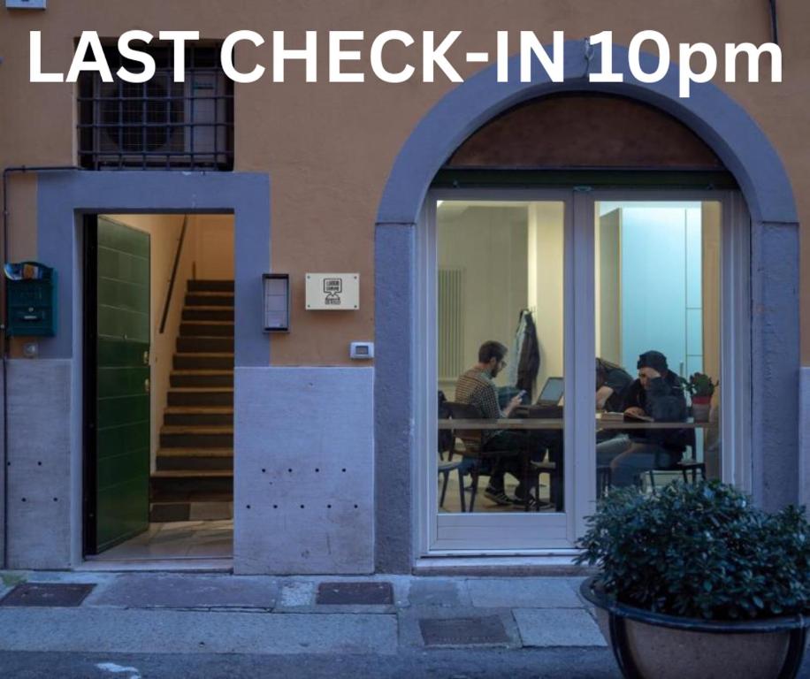 two people sitting at a table outside of a building at LUOGO COMUNE Ostello in Brescia