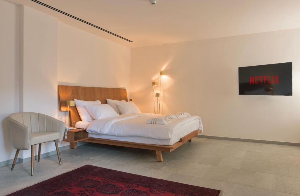 a bedroom with a bed and a chair in it at Dar Al Mauge Boutique Hotel with Outdoor Pool in Bethlehem