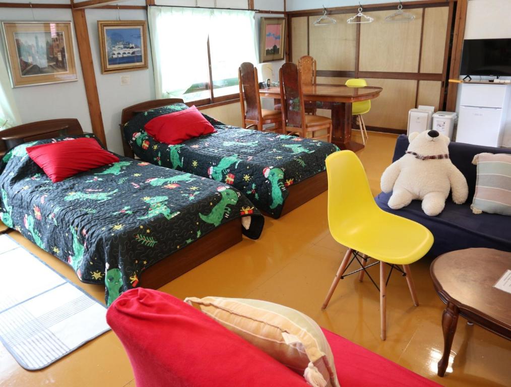 Pension Alba - Vacation STAY 70965v في تاتياما: غرفة معيشة فيها ثلاث اسرة وكرسي اصفر