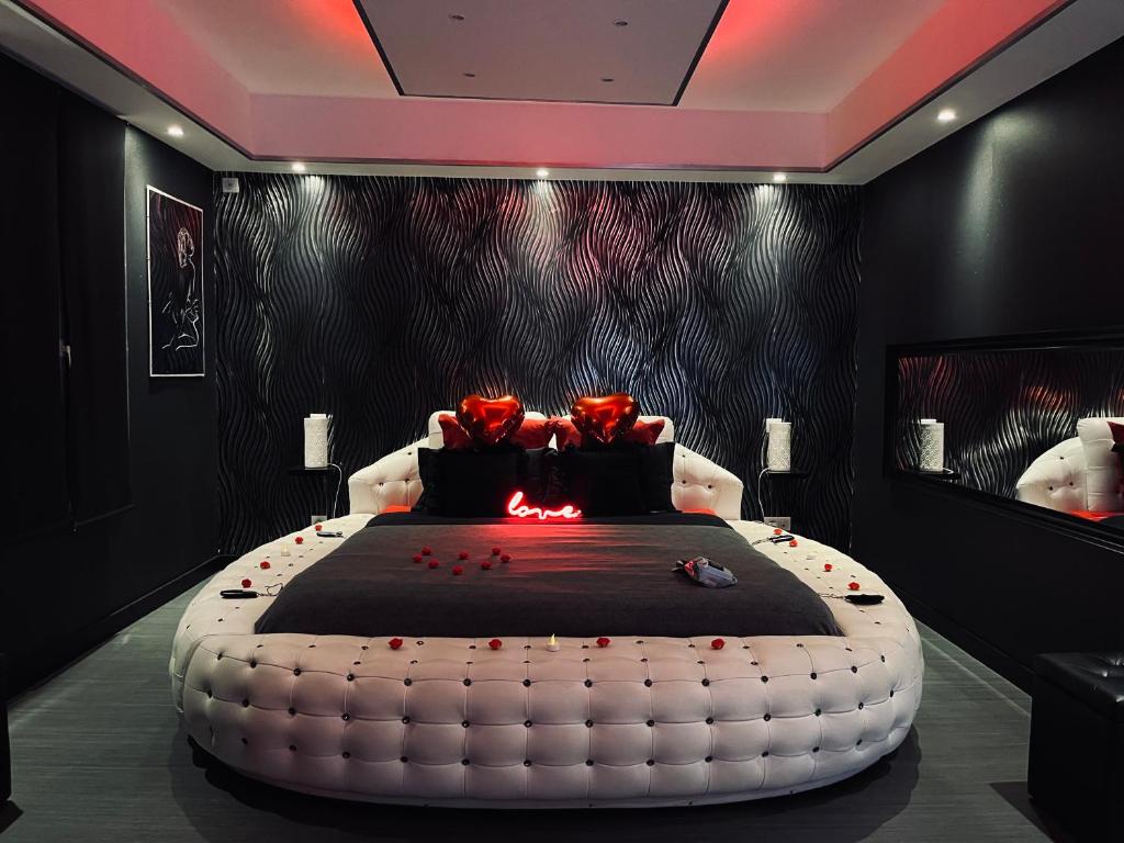 een slaapkamer met een groot wit bed met rozen erop bij La Nuit Coquine - Suite avec Jacuzzi - Evasion in Le Mans