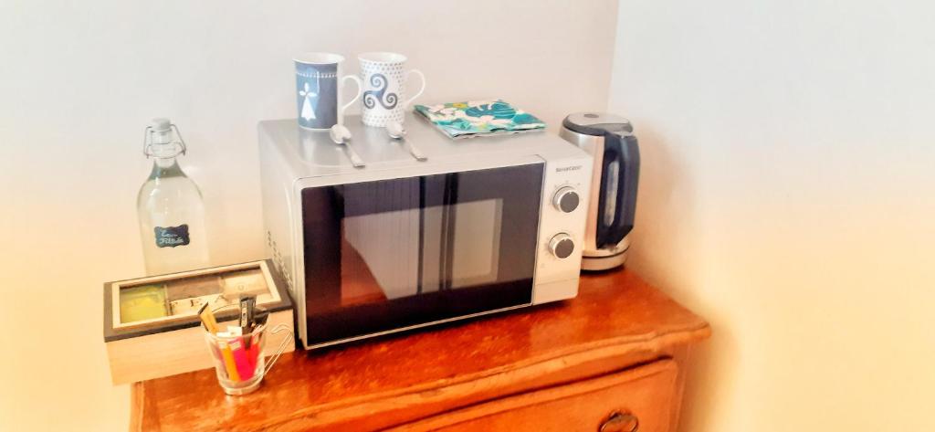 a microwave sitting on top of a wooden cabinet at " Chez Alex " 