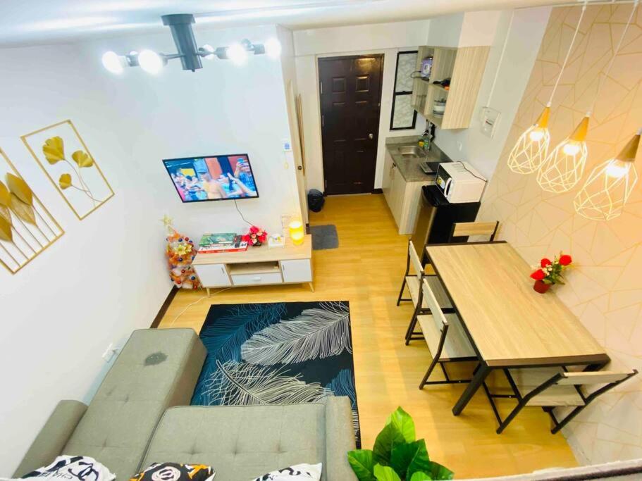 - un salon avec un canapé et une table dans l'établissement Chael Staycation - Minimalist Modern 1-Bedroom, à Marilao