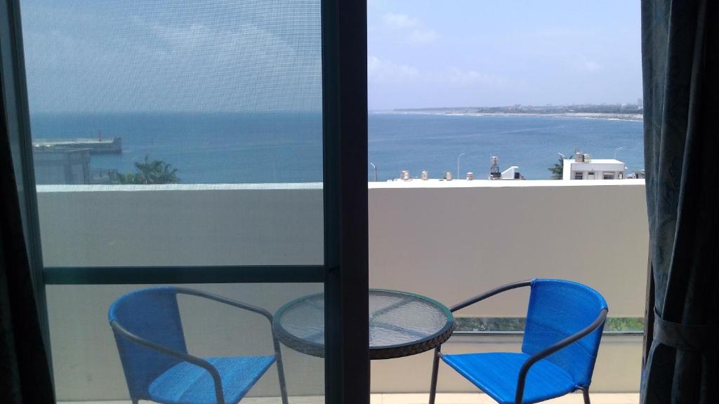 a table and chairs on a balcony with a view of the ocean at Caitlyn B&B in Taitung City