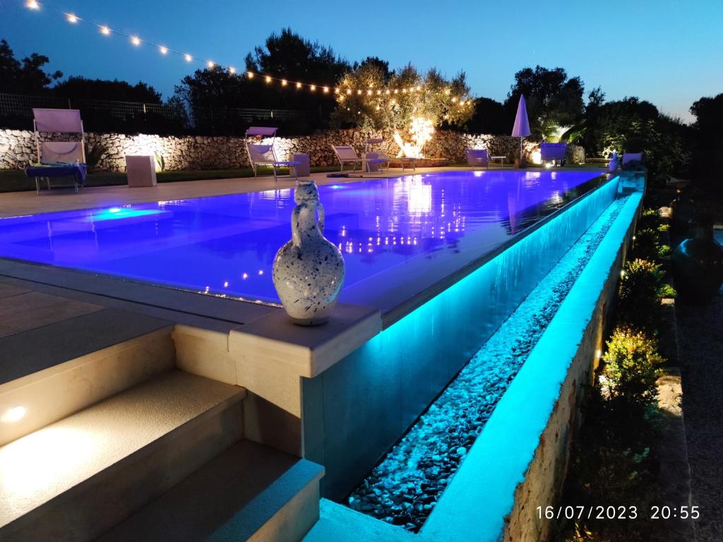 uma piscina iluminada à noite com luzes em Bed & Breakfast dei Colli em Ostuni