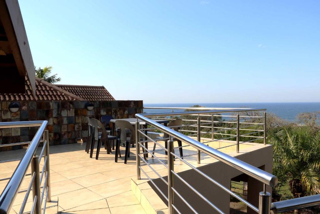 a balcony of a house with a view of the ocean at Phoenix Lodge - Ramsgate KwaZulu Natal in Margate
