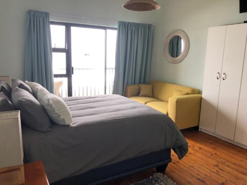 Mitford Apartments في خليج مورغانرز: غرفة نوم بسرير كبير وأريكة