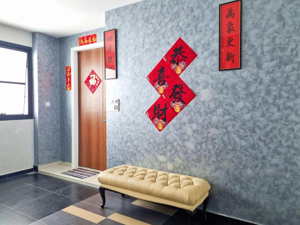 a living room with a bench and a wall with red decorations at Lion Home in Seri Kembangan